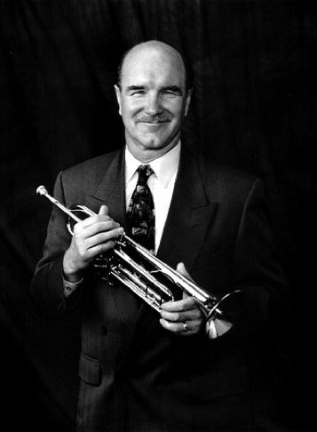 Dave Rocha wearing a suit and holding a trumpet